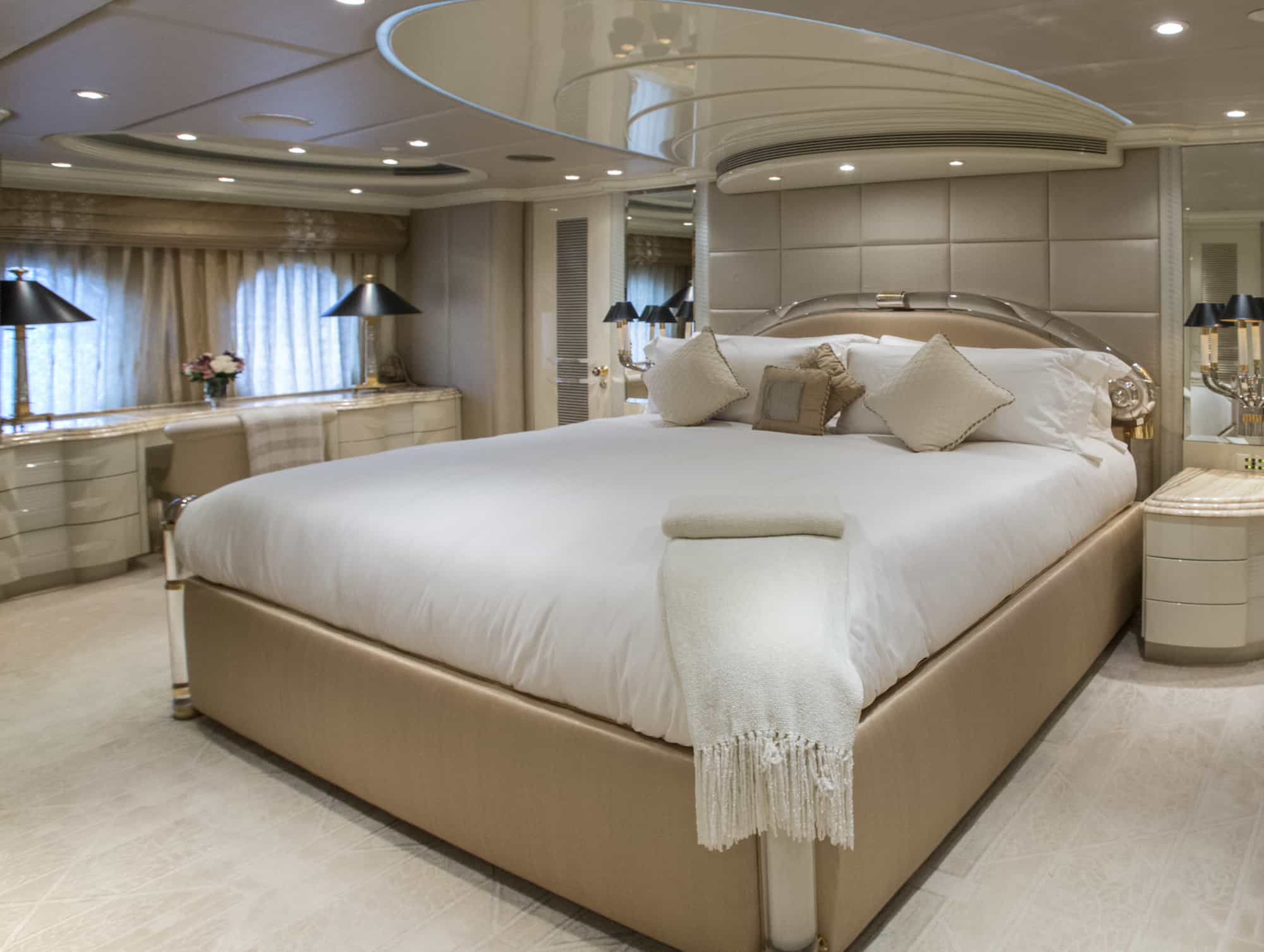 master bedroom suite onboard a luxury yacht complete with cream and white furnishings